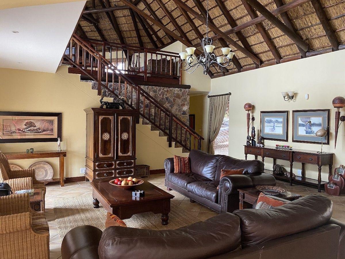 The double volume lounge under thatch, with the staircase up to the gallery landing
