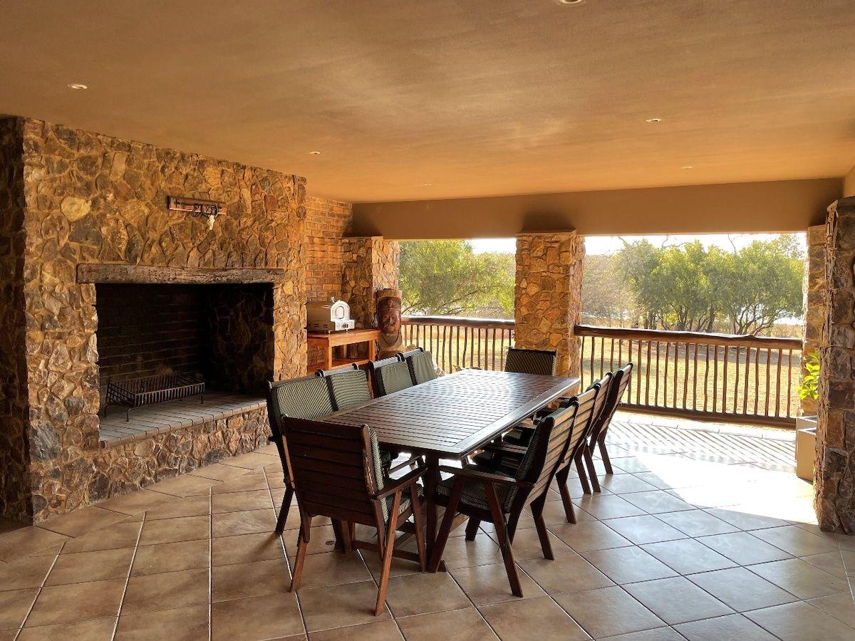 The covered patio with its stone fireplace and long dining table